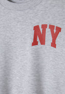 Detail of grey crew neck sweatshirt with red NY print.
