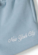 Detail of blue shorts with 'New York City' embroidery and elastic waistband.