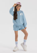 Girls crew neck sweatshirt and shorts set in light blue, featuring printed motif and ribbed cuffs.