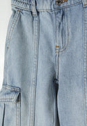 Detail of girls light blue denim cargo jeans featuring multiple side pockets and ribbed ankle cuffs.