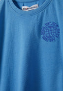 Close-up of a blue boys t-shirt featuring a round neckline and embroidered globe design.