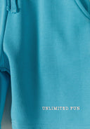 Close-up of blue fleece shorts featuring 'UNLIMITED FUN' print.
