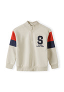 Boys half zip jumper in cream with rib cuffs and logo detail, front view.