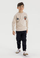 Boys oversized cream crew neck sweatshirt with graphic print, front view.