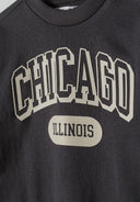Close-up of a grey boys fleece crew neck sweatshirt featuring a decorative print.