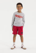 Boys red fleece shorts with ribbed side panels, front view, featuring side pockets and a decorative patch.