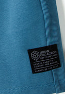 Detail of boys fleece shorts in blue with ribbed side panels and a logo patch.