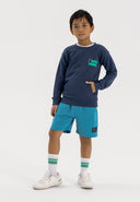 Boys fleece shorts in blue with rib side panels, featuring an elastic waistband and side pockets.