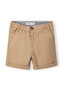 Detail of beige shorts with button fastening and side pockets.