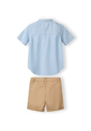 Boys grandad shirt in light blue with button fastening and beige shorts with adjustable waistband.