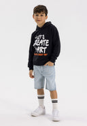 Boys light blue denim shorts with ripped design, front view, featuring pockets and zip fastening.