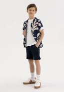 Boys navy woven chino shorts with cuffed hems and side pockets, front view.
