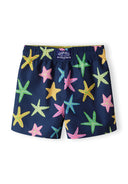 Boys board shorts in navy with colorful starfish print, back view, featuring adjustable drawstring and side pockets.