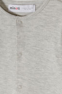 Close-up of soft grey fabric baby sleepsuit with snap buttons and minimalistic design for comfort and ease.