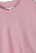 Close-up of pink kids sweatshirt with delicate heart embroidery and ribbed neckline showcasing soft fabric and simple design.