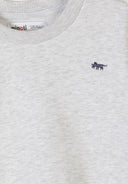 Close-up of a grey cotton sweatshirt with a small embroidered navy animal design near the neckline.
