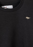 Close-up of black cotton sweatshirt with small embroidered dog design and ribbed neckline for boys' fashion.
