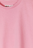 Close-up of soft pink jersey fabric with a crew neck detail, showcasing simple and comfortable kids' design.