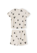 Close-up detail of cream ribbed fabric texture showing hand-drawn black hearts print pattern and crew neckline