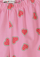 Close-up detail of pink elastic waistband shorts with watermelon heart pattern print, showing Minoti label and fabric texture