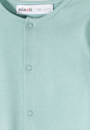 Close-up of soft mint green baby sleepsuit fabric with simple snap button design for easy wear.