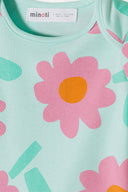 Close-up of soft fabric with a playful blue and pink floral print design for baby bodysuit fashion.