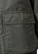 Close-up of a khaki lightweight bomber jacket pocket showing the durable fabric and detailed stitching design.