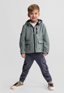 Young boy wearing a stylish waterproof teal parka with adjustable hood, paired with casual cargo pants and sneakers.