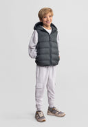 Boys quilted sleeveless waistcoat in muted olive, front view, features adjustable hood and zippered pockets.