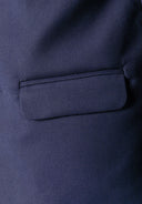 Detail of a boys' navy blue blazer showing a side flap pocket.