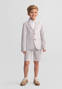 Young boy wearing a stone striped tailored cotton suit with adjustable waist shorts, smiling confidently in kids fashion style