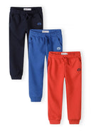 Set of three boys joggers in navy blue, red, and blue with side pockets and sporty design accents.