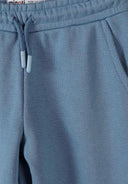 Close-up of blue boys joggers with drawstring and side pocket highlighting soft fabric design.