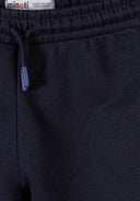Close-up of navy joggers waistband featuring elastic and matching drawstring with plastic tips, showcasing fabric texture and design details.