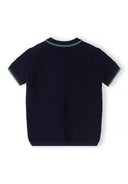 Back view of a boys' navy blue knitted polo shirt with green collar trim.