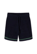 Detail of navy blue shorts with elasticated waistband and green stripe.