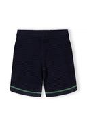 Detail of navy blue shorts with elasticated waistband and green trim.