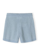 Detail of light blue elastic shorts with a ribbed waistband and mesh pattern.