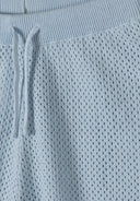 Detail of light blue elastic shorts with a textured knit and drawstring.