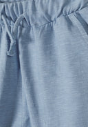 Close-up of light blue cotton jersey shorts with elastic waistband and drawstring, showcasing soft fabric texture and design.