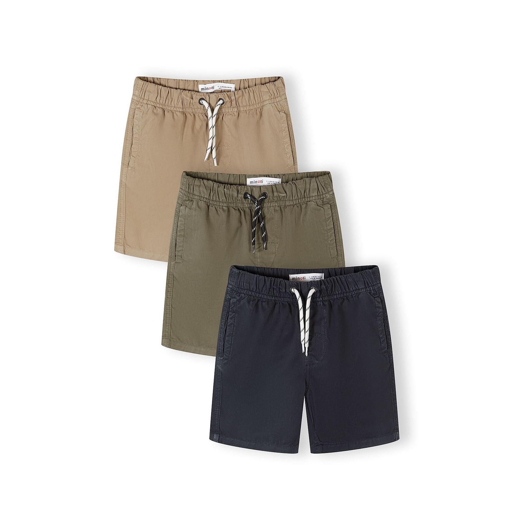 Three cotton shorts laid flat showing sand beige, olive khaki and navy blue colors with white drawstring ties and Minoti labels