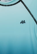 Close-up of turquoise to black ombre rash vest with seamless design and black stitching detailing