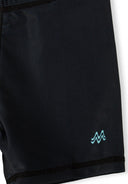 Close-up of black boys swim shorts with a small blue wave design on the leg, featuring elasticated seams.