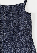 Close-up of girls sleeveless dress with a textured fabric and delicate floral print design in dark tones