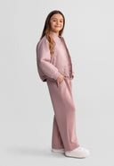 Young girl wearing a stylish lightweight pink bomber jacket with quilted design and comfortable pink pants