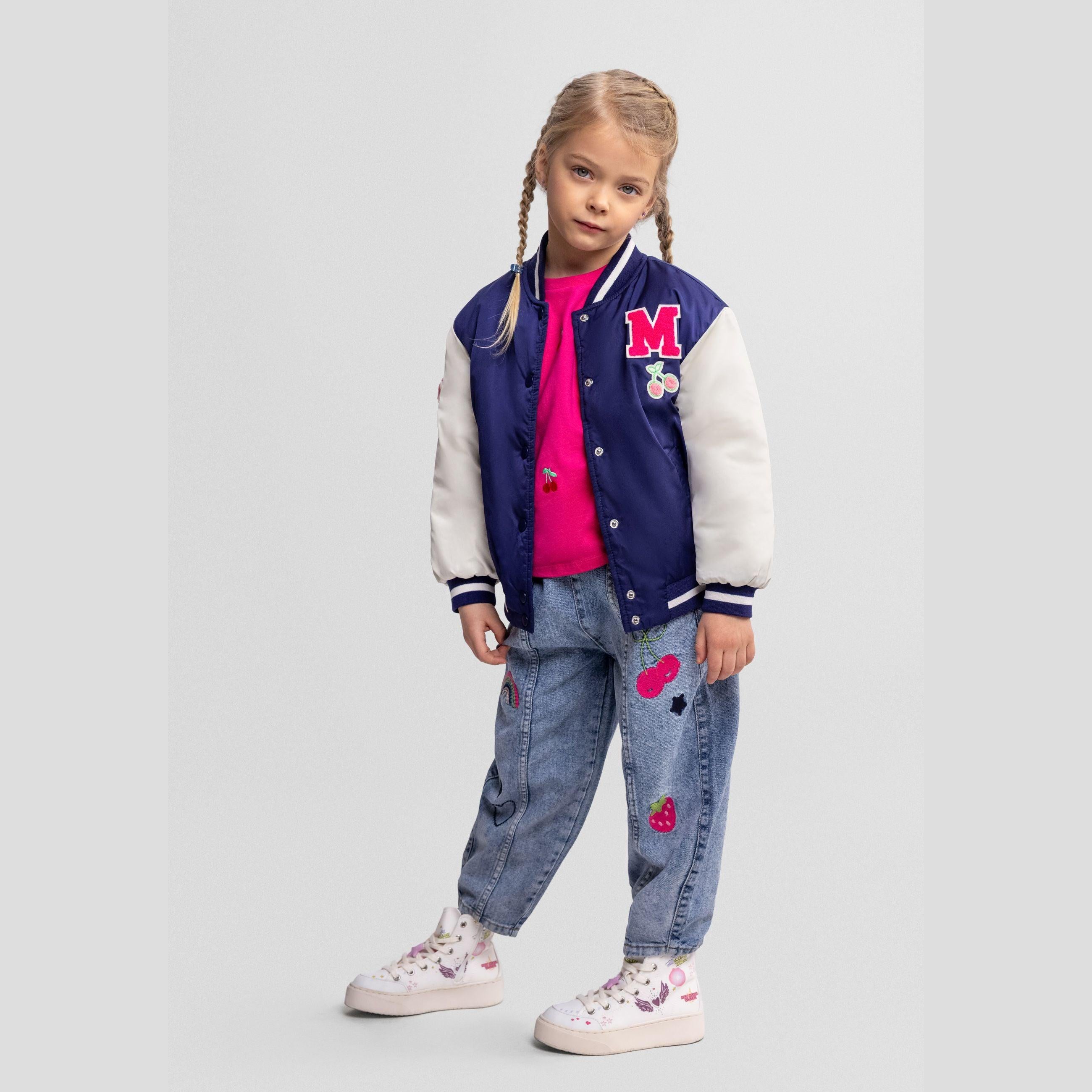 Navy bomber jacket with white sleeves laid flat showing red letter M patch and cherry embroidery details