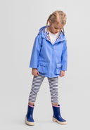 Young girl wearing a blue waterproof jacket with striped hood lining and navy rain boots, showcasing kids fashion design.