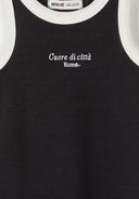 Close-up of black ribbed jersey dress with white trim and embroidered city-themed design for girls.