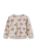 Beige kids sweatshirt featuring an all-over pink bow print design with ribbed cuffs and collar
