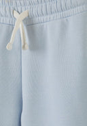 Close-up of light blue kids joggers with elastic waistband and white drawstring, highlighting soft fabric and unique design.